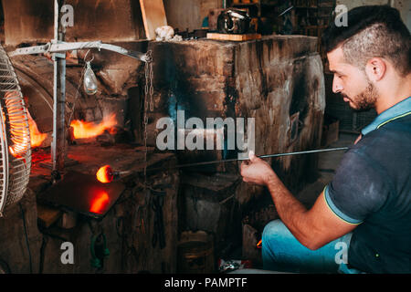 Einem jungen Glasbläser bläst ein Glas Schwan in einem Workshop in Hebron, Palästina Stockfoto