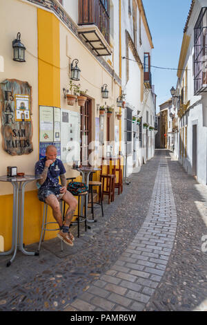 Arcos de la Frontera, Spanien - 22. Juni 2018: Mann saß an der Bar in der engen Straße. Die meisten Straßen sind ungeeignet für Fahrzeuge. Stockfoto