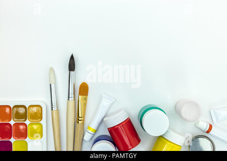 Satz von Bürsten und bunten Farben auf weißem Schreibtisch. Malerei Tools für die Schule Stockfoto
