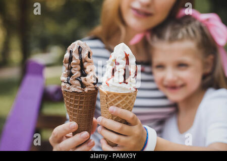 Mutter und Tochter essen Schokolade und Vanille Eis Stockfoto