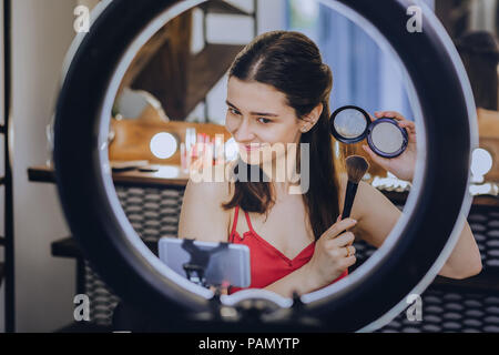 Dark-eyed woman holding Make-up-Pinsel in der Hand. Stockfoto