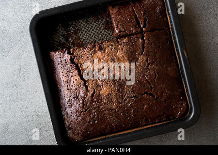 Platz saftige Schokolade Schwamm nass Kuchen mit Sauce in Form. Dessert Konzept. Stockfoto