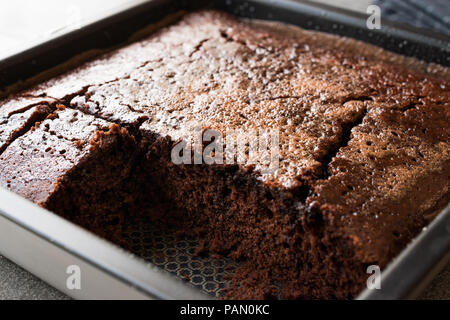 Platz saftige Schokolade Schwamm nass Kuchen mit Sauce in Form. Dessert Konzept. Stockfoto