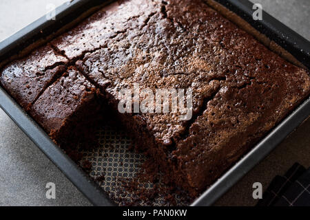 Platz saftige Schokolade Schwamm nass Kuchen mit Sauce in Form. Dessert Konzept. Stockfoto