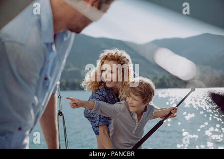 Junge mit Eltern auf einem Segeltörn nach seinem Finger Stockfoto