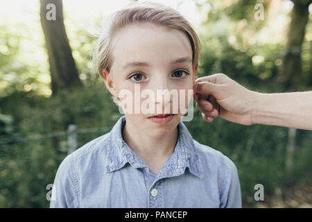 Hand, Ohr eines Jungen Stockfoto