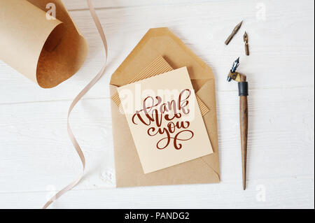 Schreiben Mockup Urlaub leeres Papier und einen Umschlag mit Stift auf Holz Tisch mit Kalligrafischen text Danke, Schriftzug Thanksgiving Day. Flach. Ansicht von oben Stockfoto