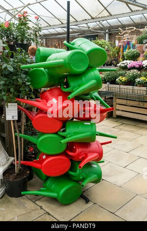 Eine ungewöhnliche Darstellung von Kunststoff farbenfrohe Gießkanne auf den Verkauf in einem Gartencenter. Stockfoto