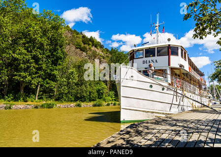 Soderkoping, Schweden - 29. Juni 2018: Gewöhnliche Sommer Tag entlang der Gota canal. Die tour Boot Diana entlang der Promenade verankert, stehende Person in Th Stockfoto