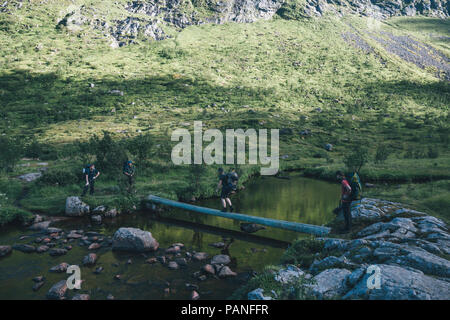 Norwegen, Lofoten, Moskenesoy, junge Männer, die Kreuzung Wasser bei Agvatnet Stockfoto