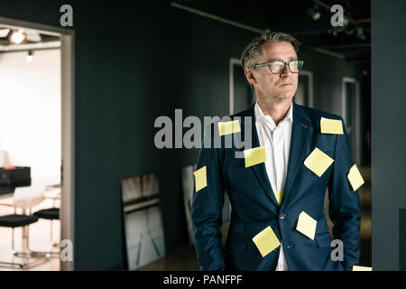 Schwere reifen Geschäftsmann bedeckt mit Haftnotizen seitlich auf der Suche Stockfoto