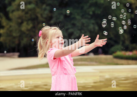 Drei Jahre alten Mädchen spielen mit Seifenblasen Stockfoto