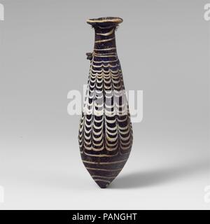 Glas alabastron (Parfüm Flasche). Kultur: Griechisch, östlichen Mittelmeer. Abmessungen: H.: 5 3/16 in. (13,1 cm). Datum: 2. bis Mitte 1. Jahrhundert v. Chr.. Transluzente Kobaltblau, mit Griffen in der gleichen Farbe; Trail im Deckweiß. Nach innen geneigte unregelmäßige Rim-Disk mit der abgerundeten Kante und strahlende Schnittspuren auf Oberfläche; zylindrische Hals, nach unten erweitert; Gerade-seitig fusiform Körper nach unten erweitert, dann Spitz, spitz unten; zwei horizontalen Stift griffen über Trail auf der Oberseite des Körpers angewendet. Trail, der am Boden, Wunde nach oben in einer Spirale zu carination, werkzeuggestützte in eine Girlande um Stockfoto