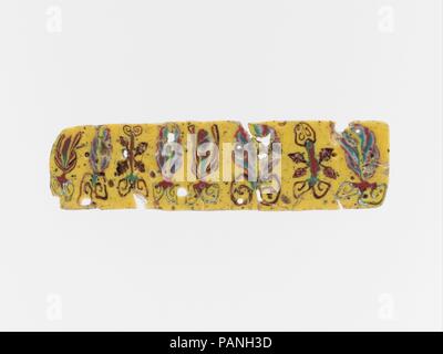Glas Mosaik Inlay. Kultur: Ägyptische, Roman. Abmessungen: Andere: 1 5/16 in. (3.3 cm). Datum: 1. Jahrhundert v. Chr. - 1. nachchristlichen Jahrhundert. Undurchsichtig Gelb undurchsichtig; Dekoration in Weiß, Rot und Grau-grün, und Translucent deep purple erscheint schwarz. Schmalen horizontalen Streifen, verjüngt sich leicht nach links und abgerundete Kante links. Asymmetrische repetitive Blumenmotiv mit Palmetten, Lotus Knospen und Triebe durch vier Efeu Blätter flankiert. Gebrochen und repariert mit einige Risse und Verluste; Obere, Unterseite, und Kanten geschliffen und poliert; tiefe Rillen der Oberfläche blasen. Der Streifen ist dekoriert mit Stockfoto