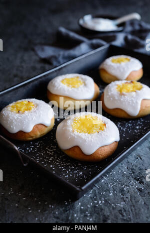 Skoleboller - traditionelle norwegische Brötchen mit Pudding auffüllen, Zucker glasieren und sprengte mit geschredderten Coconut Stockfoto