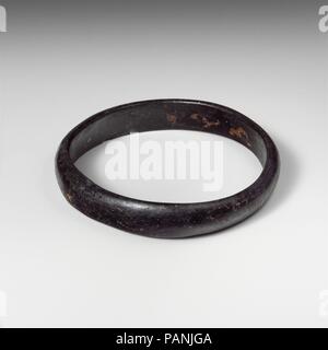 Glas Armband. Kultur: Roman. Abmessungen: W. 5/8 in. (1.6 cm), Diam. 3 1/8 in. (7,9 cm). Datum: Ca. 2.-4.Jh. N.CHR.. Transluzent blau, erscheint schwarz. Leicht oval Band mit ungleichen Seiten; halbrunde in Abschnitt mit flachen Innenseite; keine sichtbaren Naht. Intakt, außer für Chip in die Kante der Innenseite; längliche blasen; Mattierung, schwachen Schillern, und kleine Flecken von Cremigen Verwitterung. Museum: Metropolitan Museum of Art, New York, USA. Stockfoto