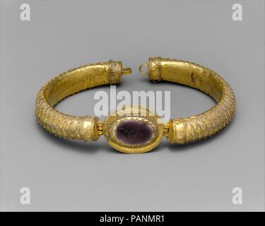 Gold und Glas Armband mit zentralen Medaillon. Kultur: Griechisch. Abmessungen: Durchmesser 3 7/16 in. (8,7 cm). Datum: 2.Jahrhundert v. Chr.. Die Besonderheit dieses Armband oder armbinde ist die Behandlung der äusseren Oberflächen der Bänder, die mit einem feinen Netz von filigranen, indem parallele Reihen von Draht in einem Zick-Zack-Muster und Punktierung der Berührungspunkte mit Granulat erstellt abgedeckt sind. Diese ungewöhnliche Dekoration ist am besten parallel in ein paar außergewöhnliche Werke von Thessalien. Es ist ein seltener Vorläufer, der eine beliebte Art der Römischen Armband mit twisted Bänder und aufklappbaren Box Einstellungen de Stockfoto