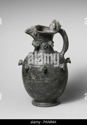 Terrakotta Kleeblatt oinochoe (Kanne). Kultur: Etrusker. Abmessungen: H. 13 11/16 in. (34,8 cm). Datum: Ca. 575-550 v. Chr.. Dieser Standard bucchero Form ist in eine exotische Krug durch die Einbindung von Staats- und zahlreichen Ton Rams, menschliche Köpfe verwandelt, und Bosse auf der Felge, Hals, Schulter und Bauch. Die Behandlung ist typisch für Vulcian bucchero Workshops. Museum: Metropolitan Museum of Art, New York, USA. Stockfoto