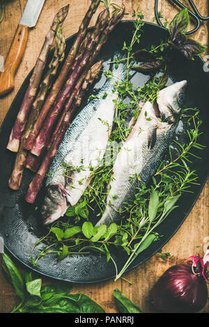 Roh ungekocht Wolfsbarsch Fisch mit Kräutern und Gemüse Stockfoto