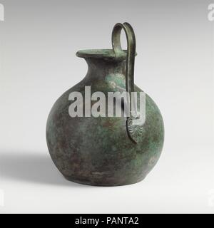 Bronze oinochoe (Kanne). Kultur: Osten griechisch. Abmessungen: H. x Breite 9 1/16 x 5 in. (23 x 12,7 cm) Durchmesser 7 in. (17,8 cm). Datum: Ende 6.Jh. v. Chr.. Griff separat gearbeitet; es kann eine alte ersetzt werden. Museum: Metropolitan Museum of Art, New York, USA. Stockfoto