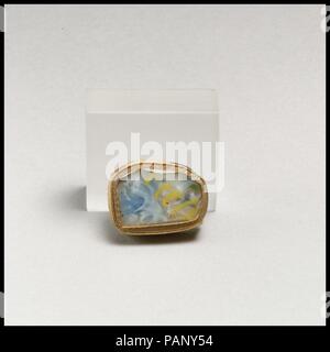 Glas Mosaik Fragment. Kultur: Roman. Abmessungen: Andere: 5/8 x 15/16 in. (1,6 x 2,4 cm). Datum: Ende 1.Jh. v. Chr. - frühe 1. Jh. N.CHR.. Dünnwandige Fragment, vielleicht von einem Inlay. Transluzent blau, opak weiß und gelb und farblos. Flach, mit zwei Stright Kanten bilden eine rechtwinklige Ecke. Verwirrt Muster von Mosaik Längen einschließlich eine farblose Netzwerk Zuckerrohr Wunde spiralförmig mit einem gelben Faden. Poliert auf der oberen Seite; Vertiefungen der Oberfläche Blasen auf der oberen Seite; Mattierung und cremig irisierende Verwitterung auf der Unterseite und Kanten. Museum: Metropolitan Museum of Art, New York, USA. Stockfoto