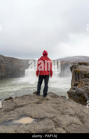 Island, North Island, jungen Mann zum Wasserfall suchen Stockfoto