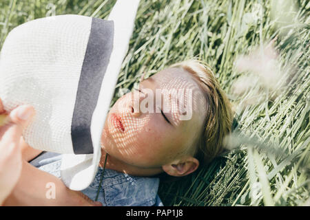Junge mit Hut liegen im Feld Stockfoto