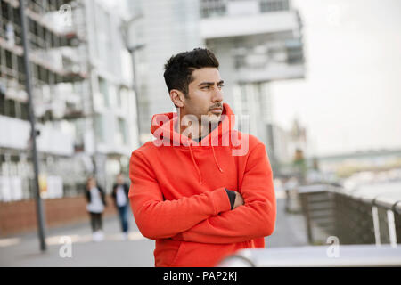 Portrait von modischen jungen Mann mit roten Kapuzenjacke Stockfoto
