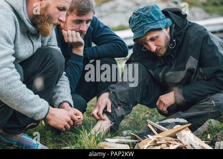 Norwegen, Lofoten, Moskenesoy, junge Männer, die ein Lagerfeuer. Stockfoto