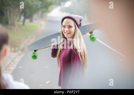 Lächelnd Jugendmädchen Holding skateboard Treffen mit Freund Stockfoto