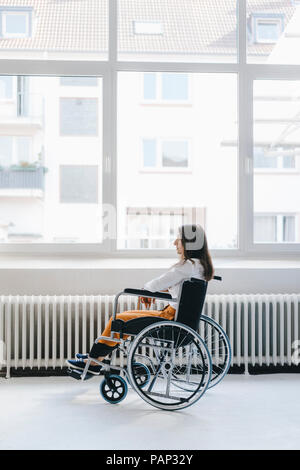 Junge behinderte Frau sitzt im Rollstuhl Stockfoto