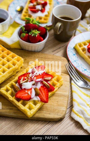 Waffel garniert mit Erdbeeren, griechischem Joghurt und Mandeln auf Frühstückstisch Stockfoto