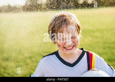 Junge tragen Deutsche Fußball-Shirt in Spritzwasser Stockfoto