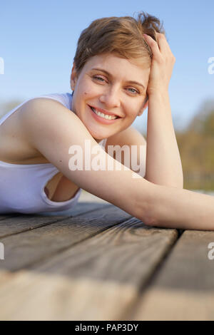 Portrait von Frau liegend auf Jetty Stockfoto