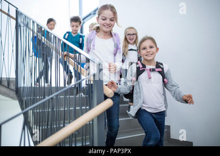 Glückliche Schüler im Treppenhaus der Schule Stockfoto