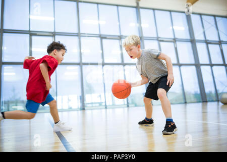 Zwei Schuljungen Basketball spielen in der Turnhalle Klasse Stockfoto