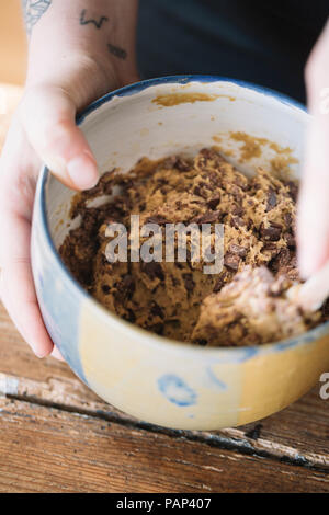 Woman's Hand, die Schüssel von vorbereiteten Teig für hausgemachte vegan Kichererbse cookies, close-up Stockfoto