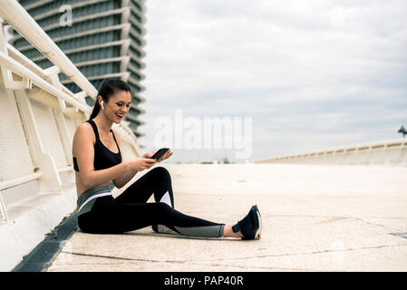 Sportliche Frau mit Smartphone Stockfoto