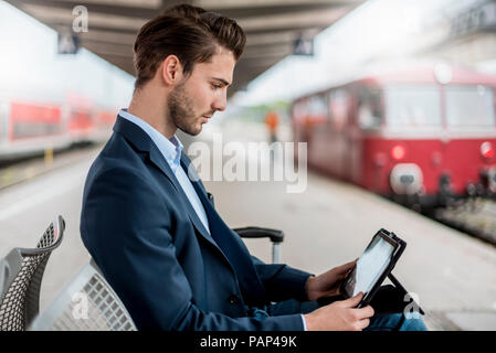 Geschäftsmann an der Station mit Tablet Stockfoto