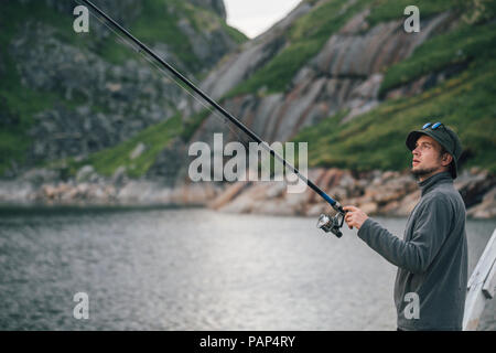 Norwegen, Lofoten, Moskenesoy, junger Mann angeln am Krokvatnet Stockfoto