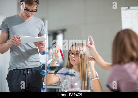 Studenten in den Bereichen Wissenschaft Klasse mit Reagenzgläsern und Tablet Stockfoto