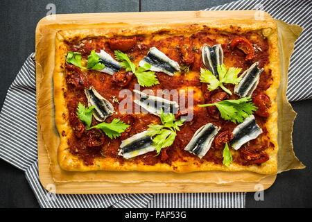 Pizza Marinara garniert mit Sardellen und Petersilie Stockfoto