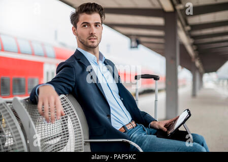 Geschäftsmann an der Station mit Tablet Stockfoto