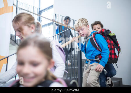 Glückliche Schüler im Treppenhaus der Schule Stockfoto