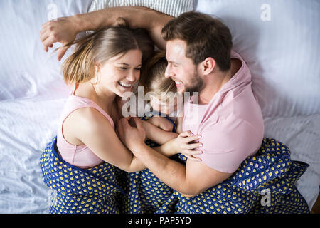 Happy Family im Bett liegen, kuscheln Stockfoto