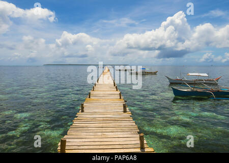 Holzbrett Gehweg auf dem Meer, mit Fluffy Clouds und Angedockten Boote - Allgemeine Luna, Siargao Island - Philippinen Stockfoto