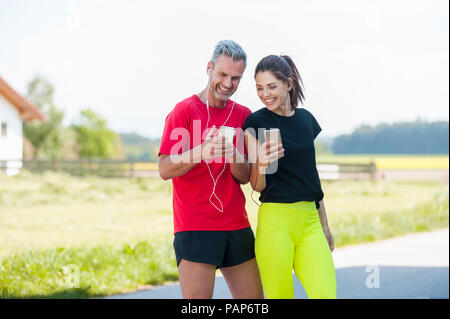 Paar mit Smartphones während des Trainings Stockfoto