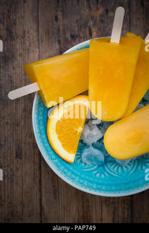 Hausgemachte orange Eis am Stiel in der Schüssel Stockfoto