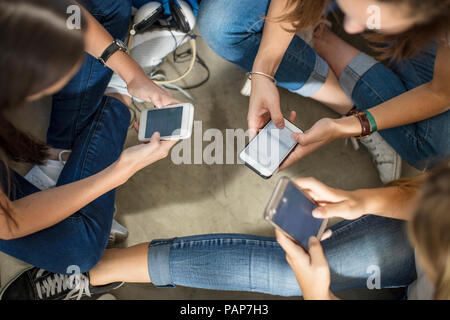 Jugend Mädchen sitzt auf dem Boden mit Handys Stockfoto