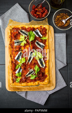 Pizza Marinara garniert mit Sardellen und Petersilie Stockfoto